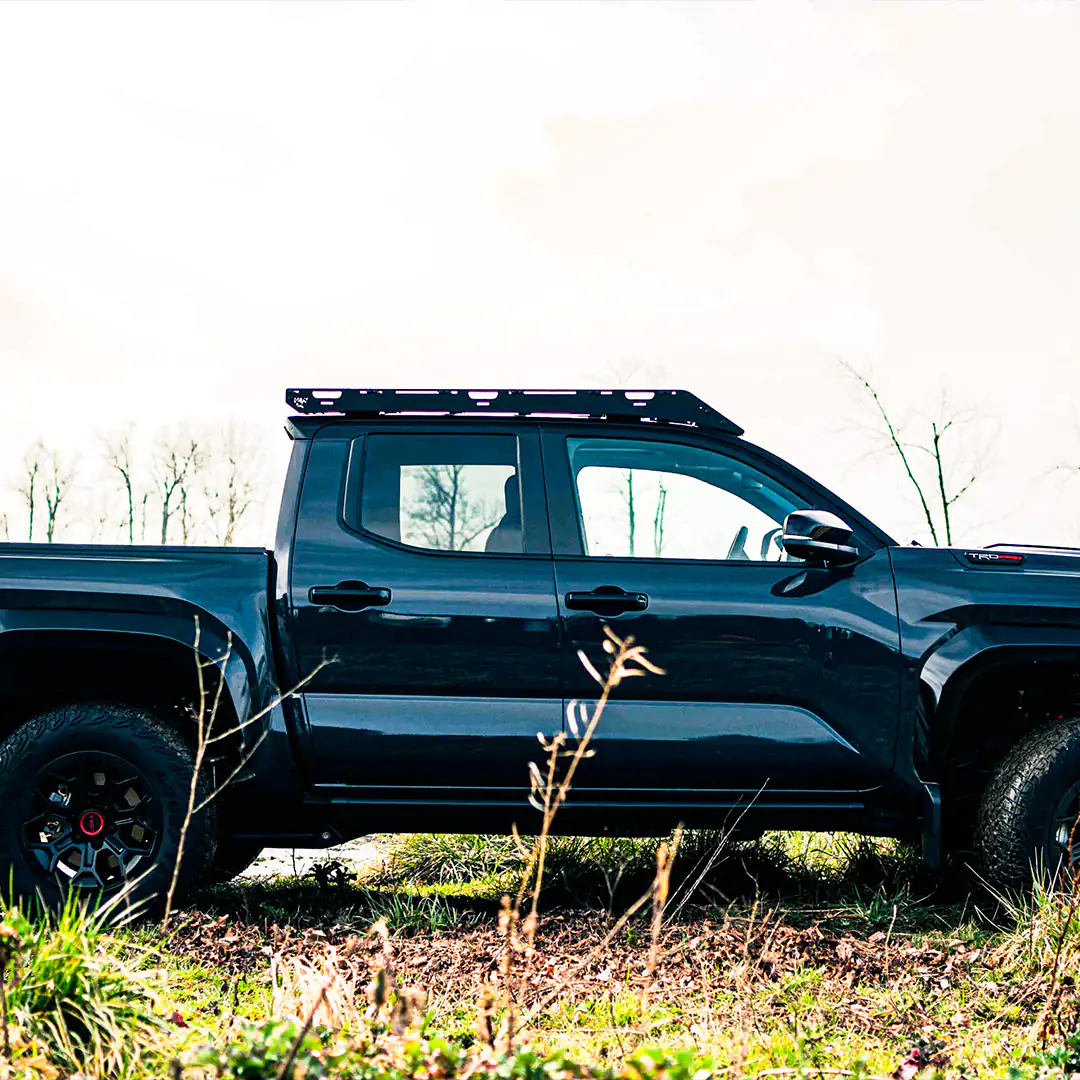 Side and Large View of the 4th gen Toyota Tacoma with a black color an an overlanding roof rack