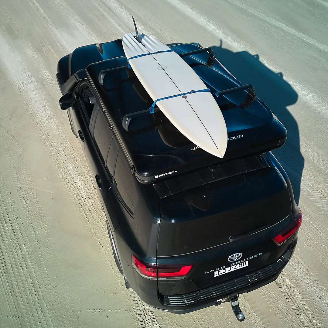 Crossbars with a surf board on the rooftop tent