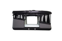 Side view of the black roof top tent with lights on and windows open
