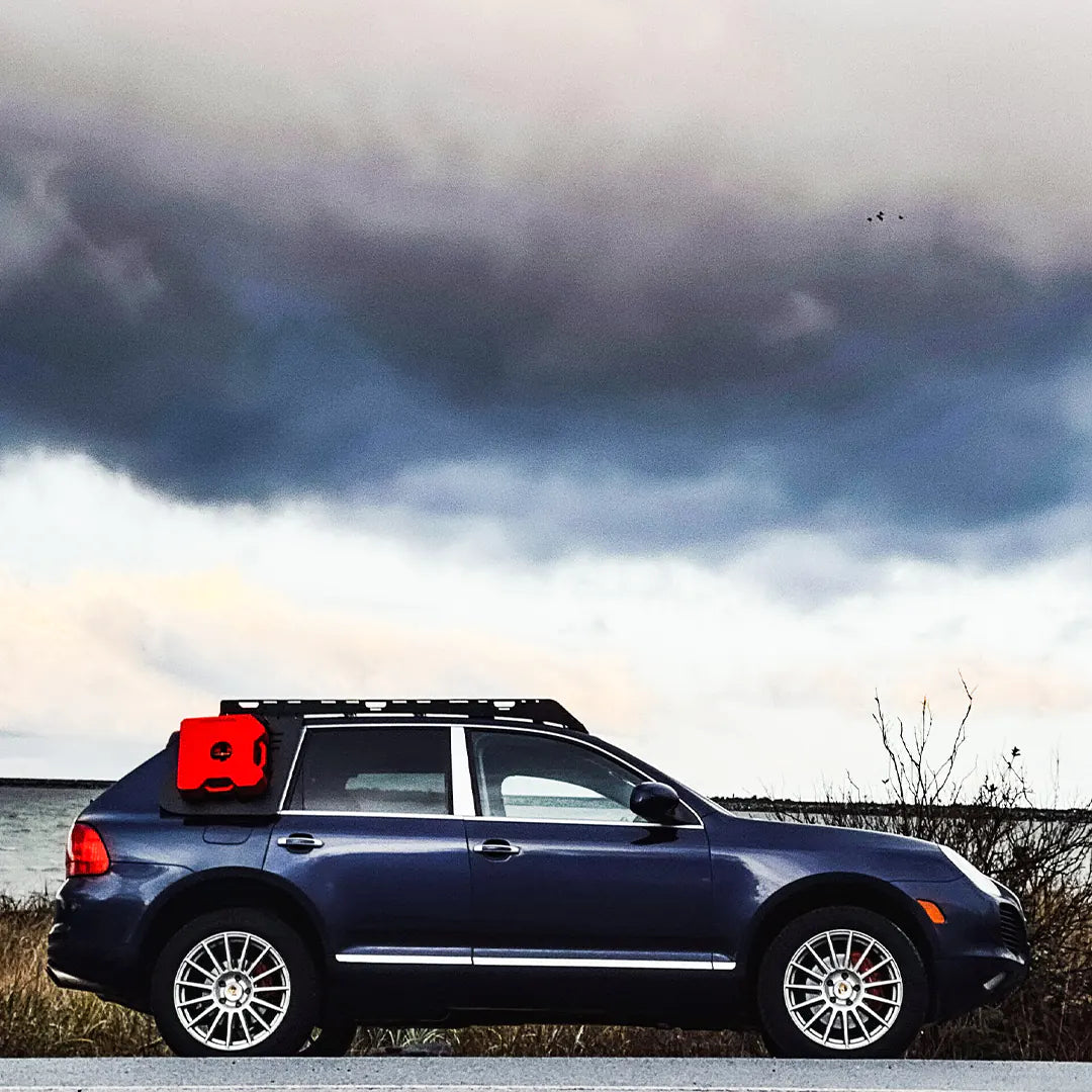 Large view of the Porsche Cayenne with Rotopax gas can on the side and lake background